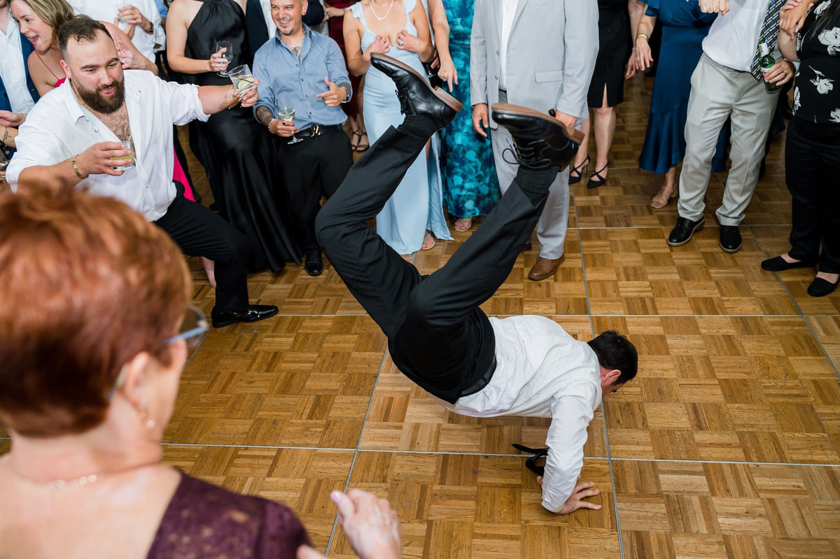 A wedding guest spinning in the middle of the dance floor, late in the night